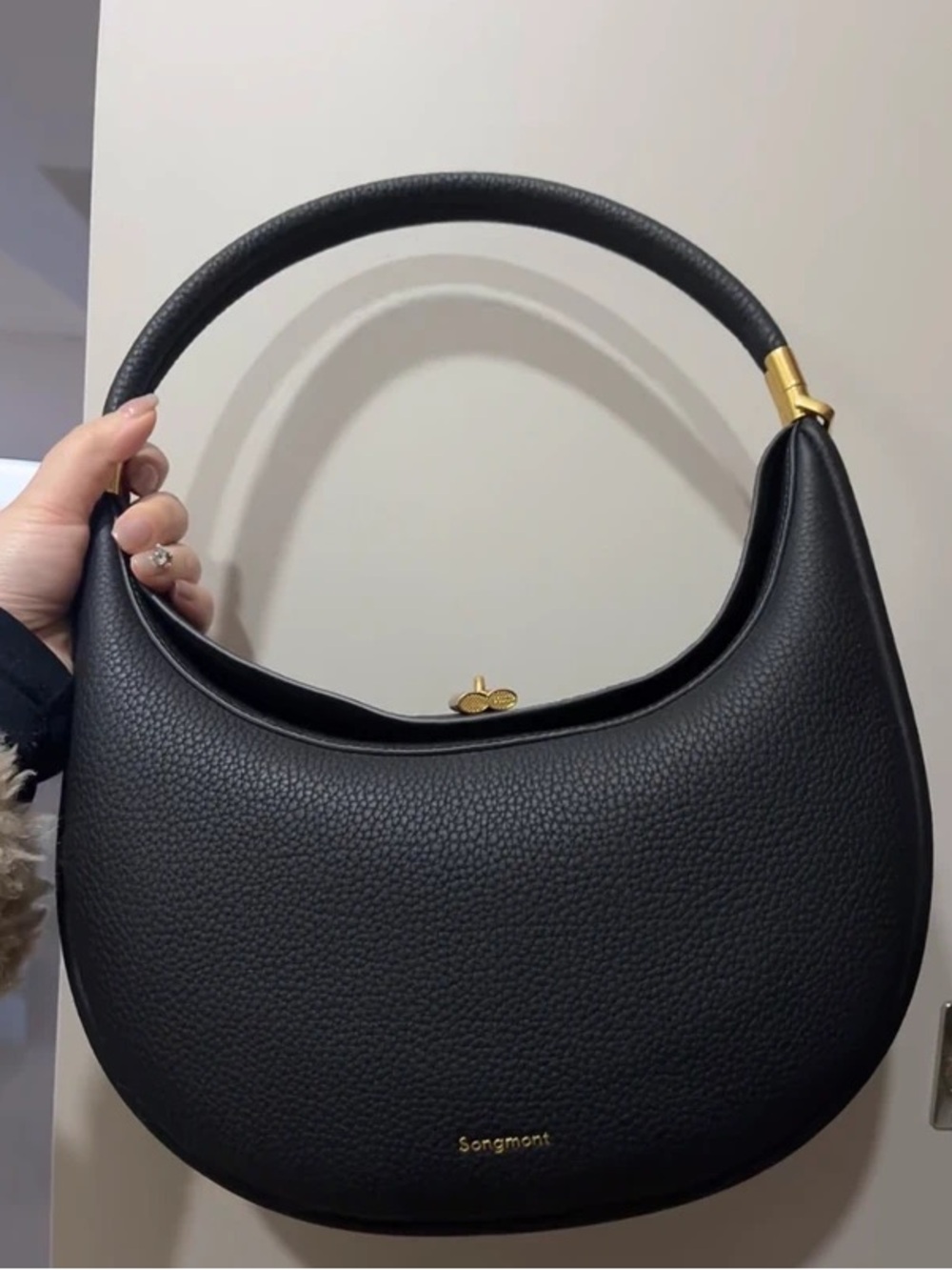 Songmont Black Pebbled Crescent Shoulder Bag with Gold Accents